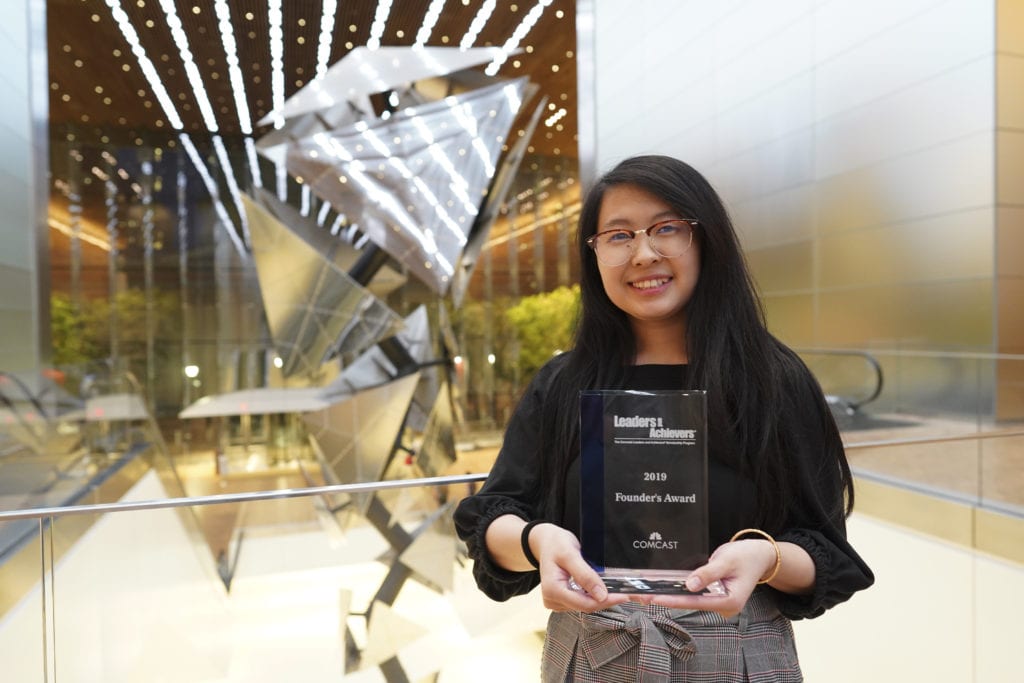 Woman holding a "Founders Award"