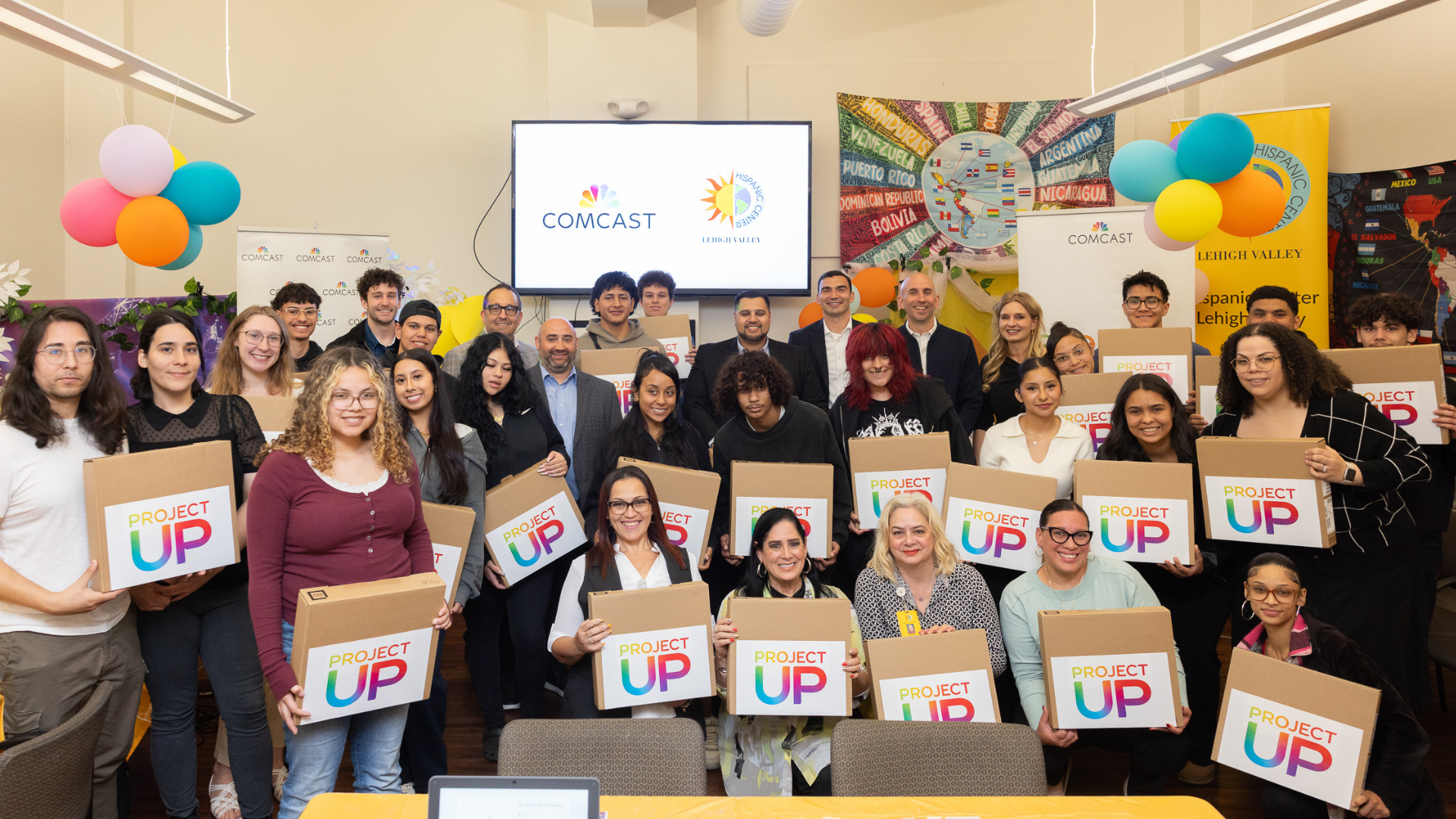 Comcast representatives, local officials, Hispanic Center Lehigh Valley staff with students, after receiving their new laptops.