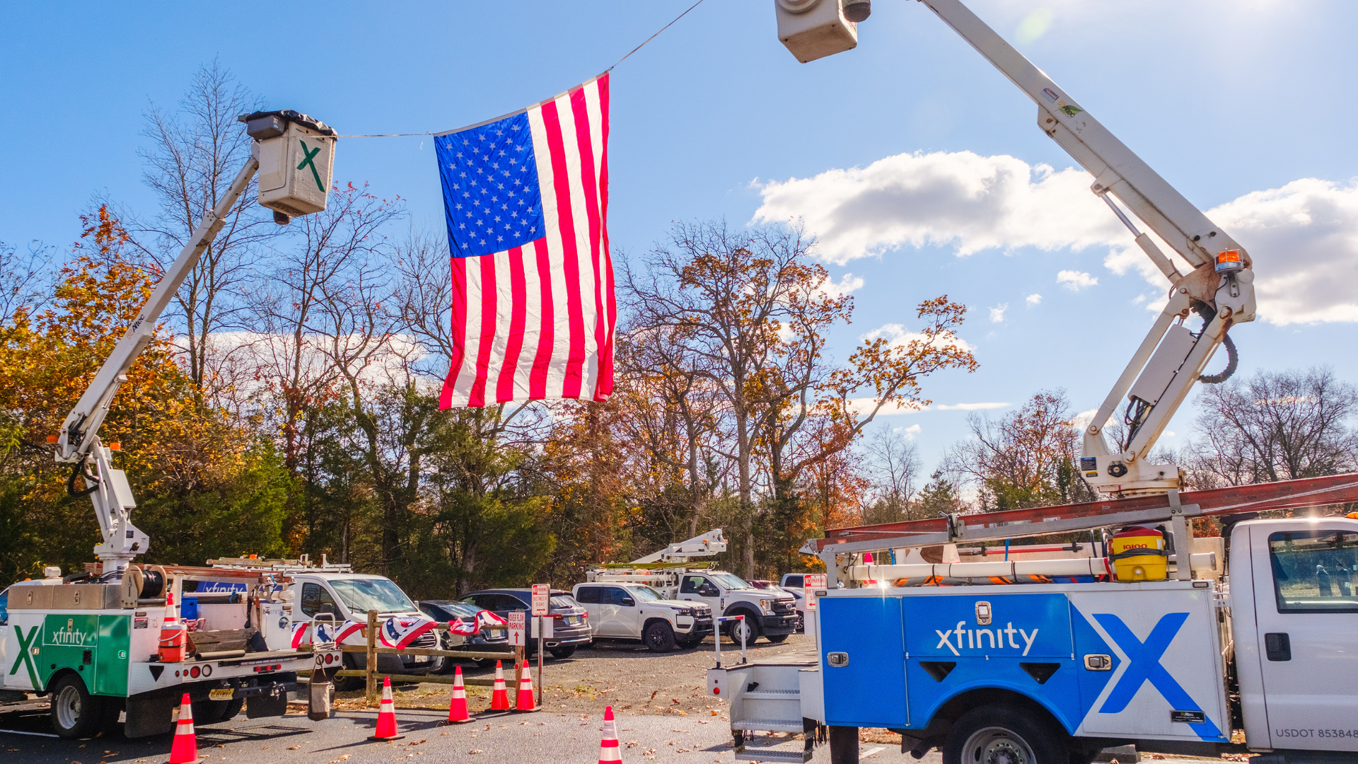 Xfinity bucket trucks with American flag.